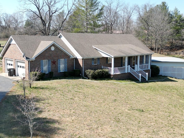 single story home featuring brick siding, a front lawn, a porch, a garage, and driveway