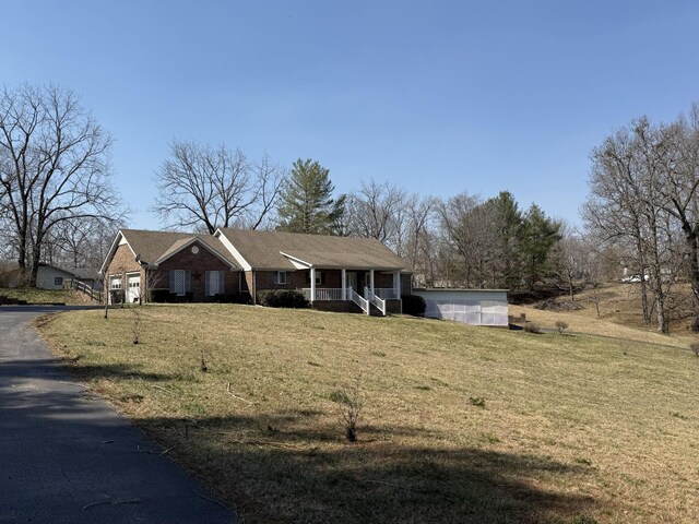 view of front of home featuring covered porch and a front lawn