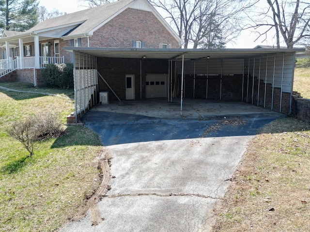 exterior space featuring a carport, a garage, brick siding, and driveway