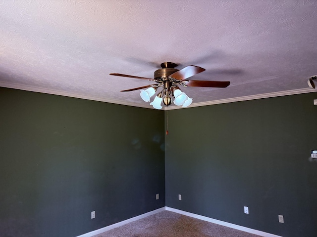 unfurnished room with dark colored carpet, baseboards, a textured ceiling, and crown molding