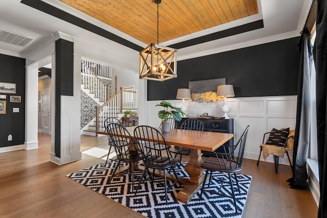 dining area featuring visible vents, stairway, a tray ceiling, wooden ceiling, and wood finished floors