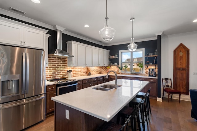 kitchen with visible vents, a sink, appliances with stainless steel finishes, wall chimney exhaust hood, and open shelves