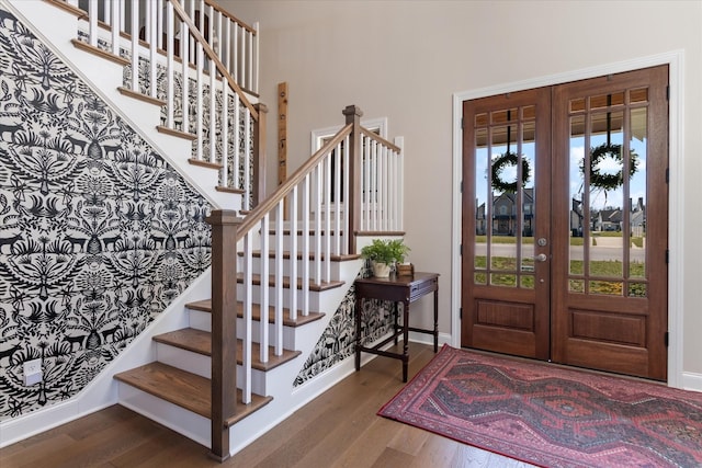 entryway featuring stairway, wood finished floors, baseboards, and french doors