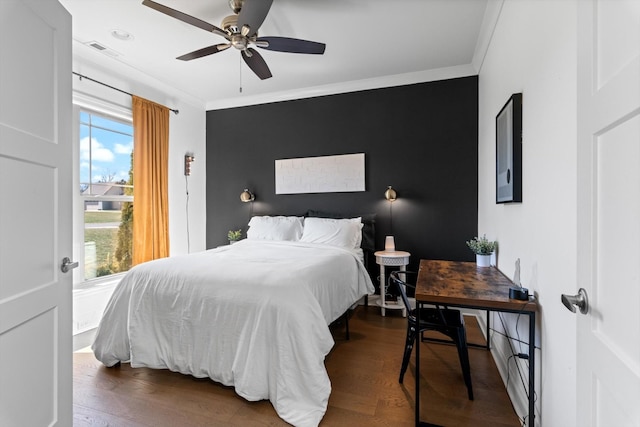 bedroom featuring visible vents, crown molding, dark wood-type flooring, and ceiling fan