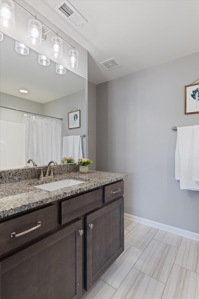 full bathroom with visible vents, vanity, and baseboards