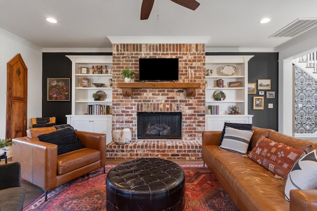 living room with recessed lighting, visible vents, a fireplace, and crown molding