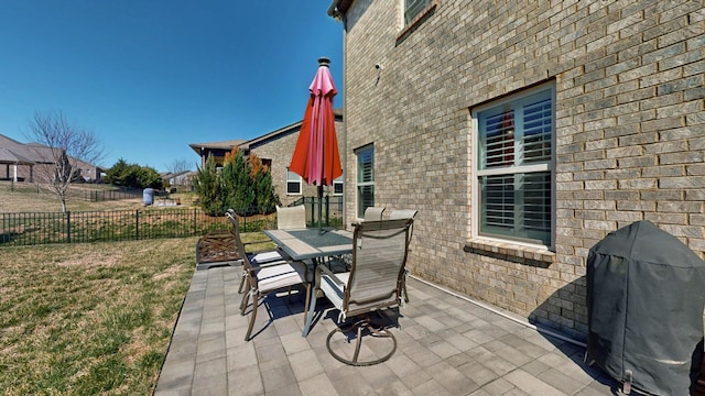 view of patio featuring outdoor dining space, fence, and grilling area