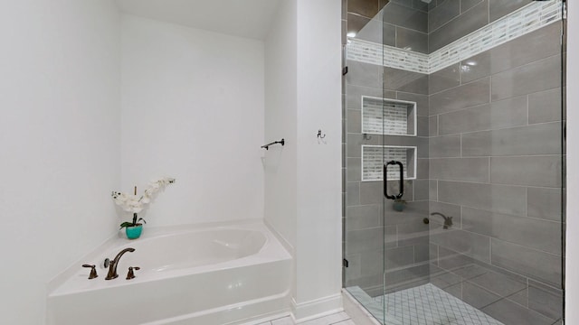 bathroom featuring a garden tub, baseboards, and a stall shower