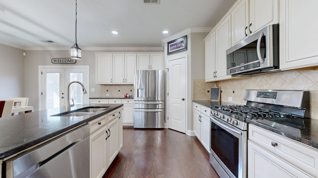 kitchen featuring a sink, white cabinetry, stainless steel appliances, crown molding, and dark wood-style flooring