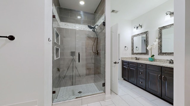 bathroom featuring tile patterned flooring, a shower stall, double vanity, and a sink