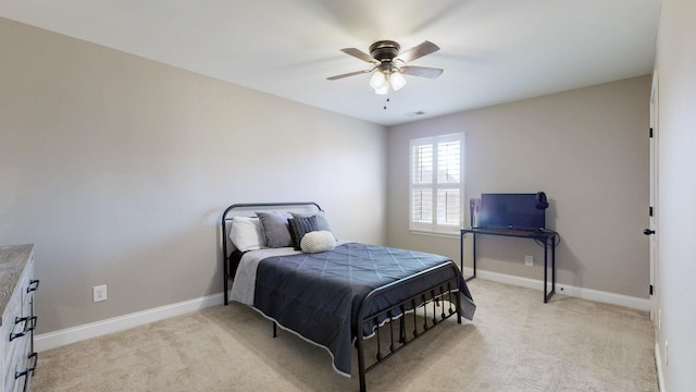 bedroom with a ceiling fan, baseboards, and light carpet