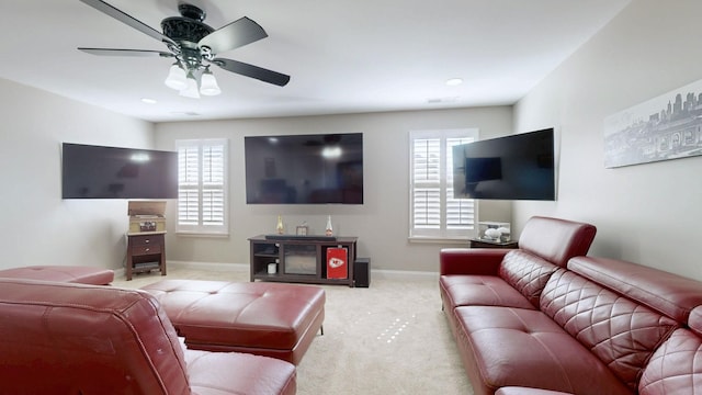 carpeted living room featuring a ceiling fan, visible vents, a healthy amount of sunlight, and baseboards