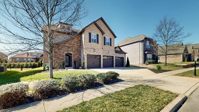 view of front of home with central AC unit, driveway, a front lawn, stone siding, and a garage