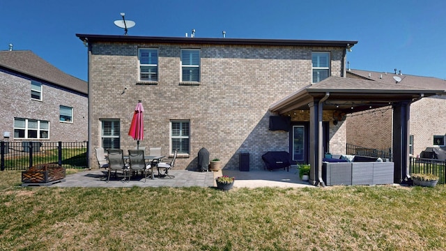 rear view of house featuring fence, a lawn, outdoor lounge area, and a patio area