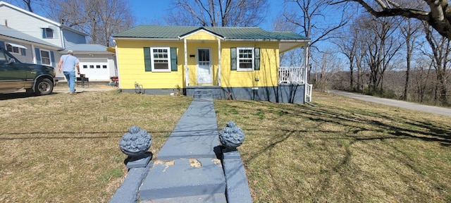 view of front of house featuring crawl space, covered porch, metal roof, and a front yard