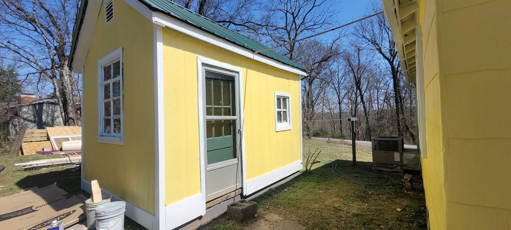 view of property exterior with an outdoor structure and central AC