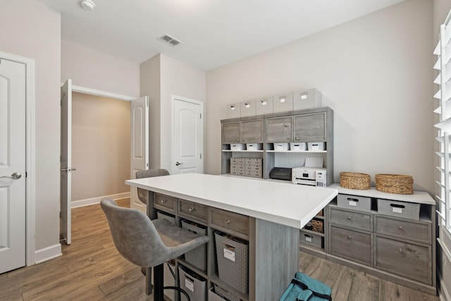 office area with visible vents, baseboards, and wood finished floors