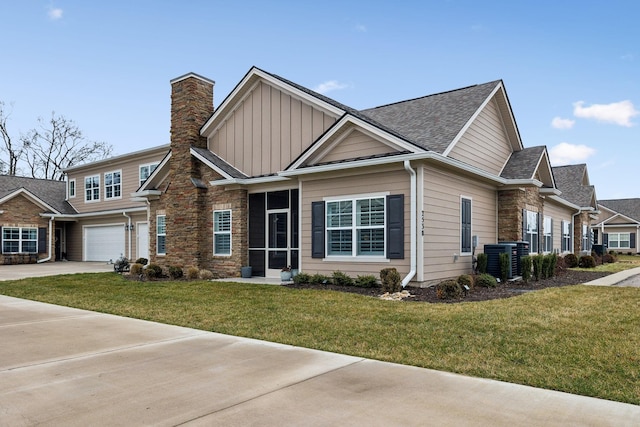 view of front of property with board and batten siding, a front lawn, stone siding, and driveway