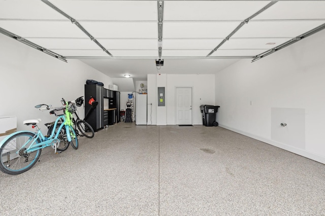 garage featuring electric panel, a garage door opener, and freestanding refrigerator