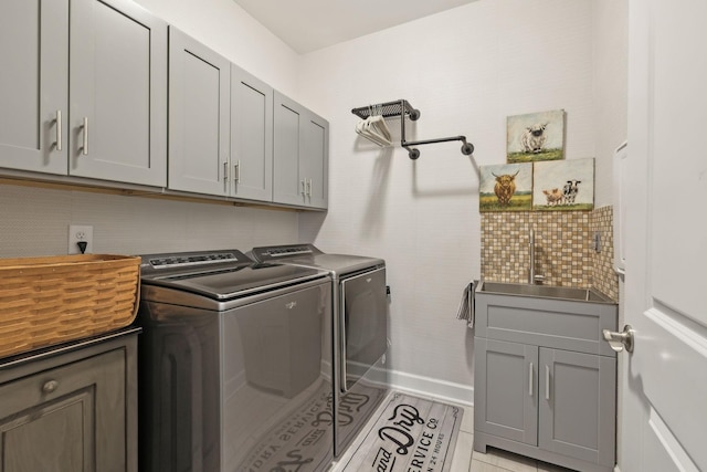 laundry area featuring cabinet space, washing machine and dryer, and a sink