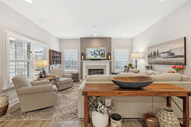 living room with plenty of natural light, recessed lighting, a fireplace, and wood finished floors