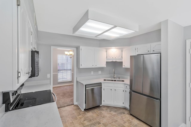 kitchen with a sink, appliances with stainless steel finishes, white cabinets, and light countertops