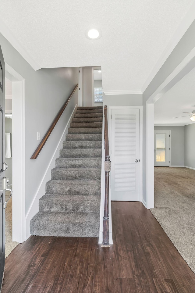 staircase with ceiling fan, baseboards, and wood finished floors