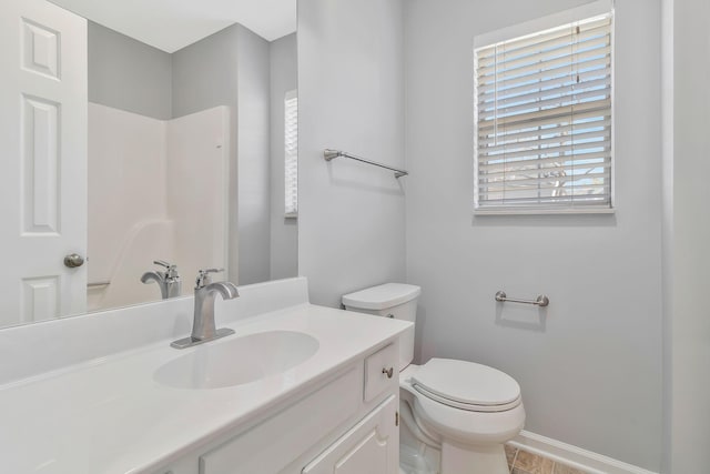 full bath with vanity, toilet, and baseboards