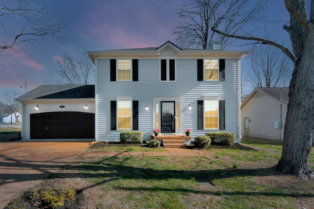 colonial home featuring an attached garage and driveway