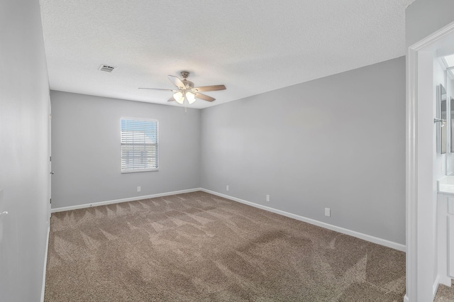 spare room with visible vents, carpet floors, and a textured ceiling