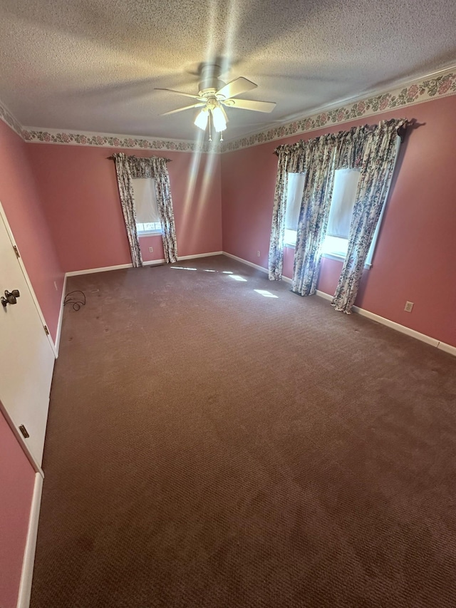 empty room with baseboards, a textured ceiling, ceiling fan, and dark carpet