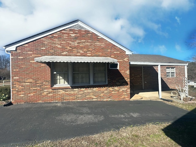 rear view of property featuring brick siding and a patio area