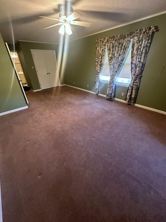 empty room featuring baseboards, carpet floors, ceiling fan, ornamental molding, and a textured ceiling