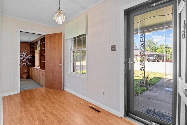 134 N Forrest Ave, Camden, TN 38320 - entrance foyer with wallpapered walls, light wood finished floors, baseboards, plenty of natural light, and crown molding