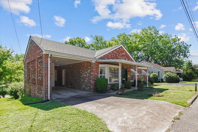134 N Forrest Ave, Camden, TN 38320 - view of front of home with brick siding, driveway, a front lawn, an attached carport, and a shingled roof