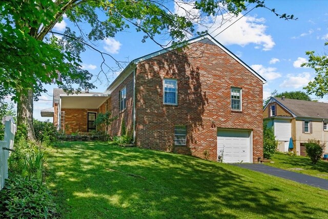 134 N Forrest Ave, Camden, TN 38320 - view of side of home with brick siding, a garage, a yard, and asphalt driveway