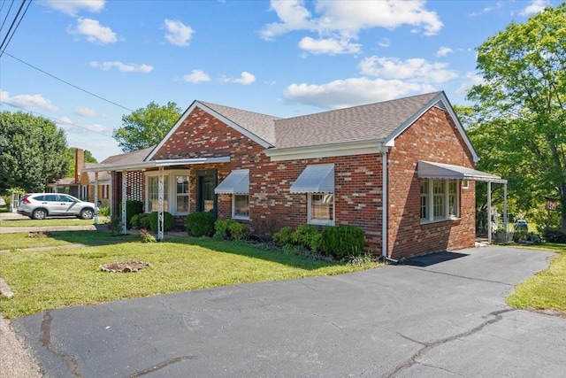 134 N Forrest Ave, Camden, TN 38320 - view of front of property featuring brick siding, a front lawn, roof with shingles, and driveway