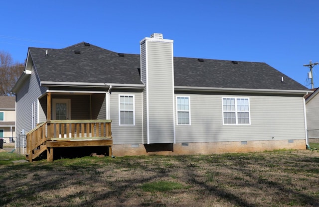 rear view of property with a yard, a chimney, roof with shingles, and crawl space