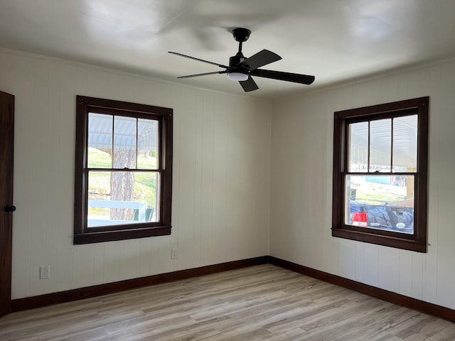 spare room featuring a ceiling fan, light wood-style floors, and baseboards