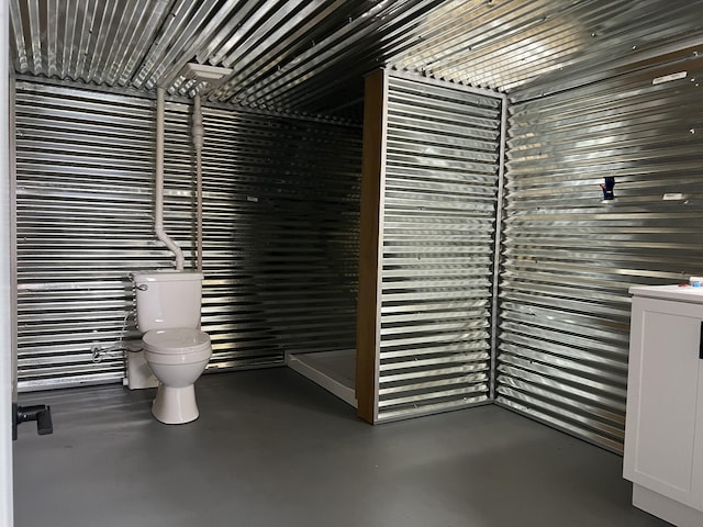 bathroom featuring toilet and concrete flooring