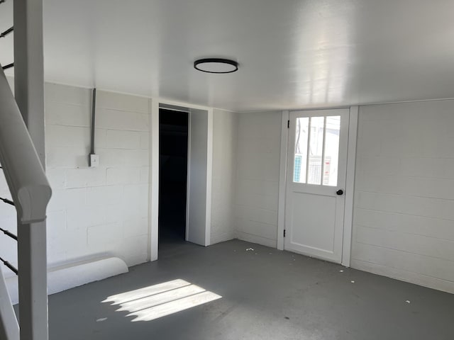 interior space featuring finished concrete floors and concrete block wall