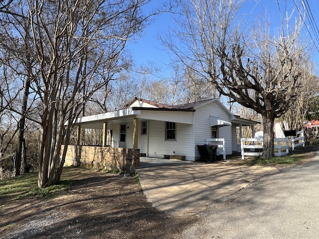 view of front facade featuring an attached carport, a porch, and driveway