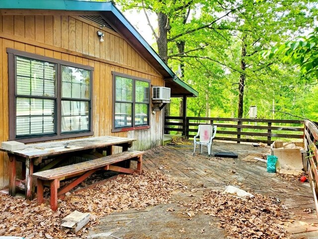 view of property exterior featuring a wall mounted AC and a wooden deck
