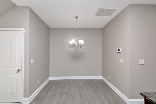 unfurnished dining area with a chandelier, visible vents, baseboards, and light wood-style floors