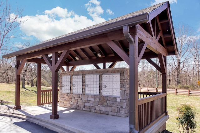 surrounding community featuring a gazebo, mail area, and fence