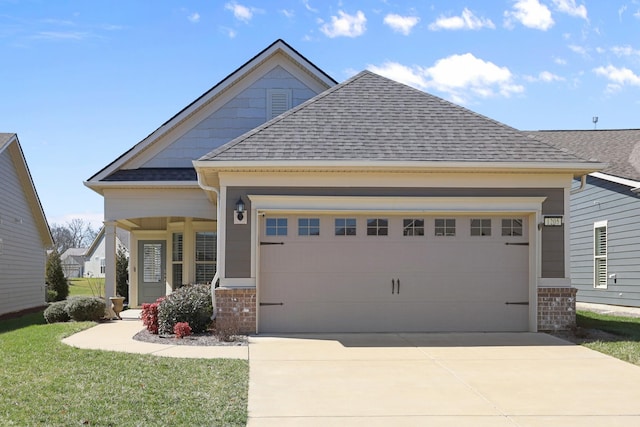 craftsman inspired home featuring roof with shingles, concrete driveway, a front lawn, a garage, and brick siding