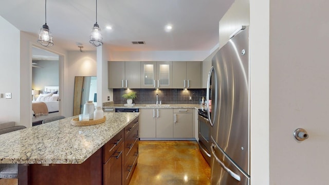 kitchen featuring visible vents, backsplash, finished concrete flooring, stainless steel appliances, and a sink