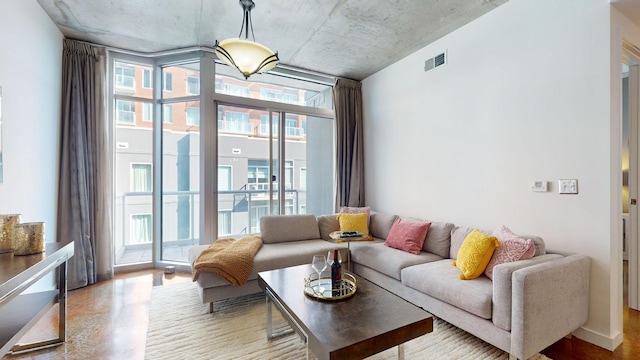 living area with visible vents, concrete flooring, and expansive windows