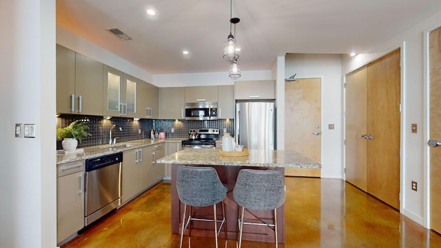 kitchen featuring finished concrete flooring, visible vents, a sink, stainless steel appliances, and tasteful backsplash