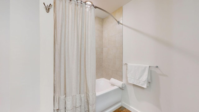 full bath featuring baseboards and shower / bathtub combination with curtain